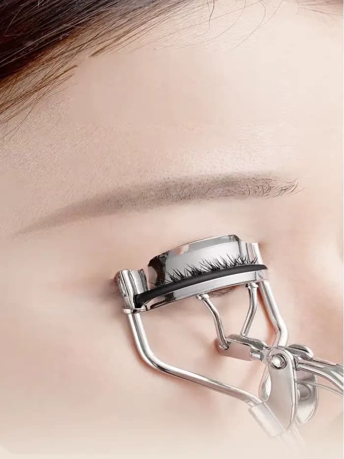 Recourbe-cils professionnel en acier inoxydable avec une poignée confortable.